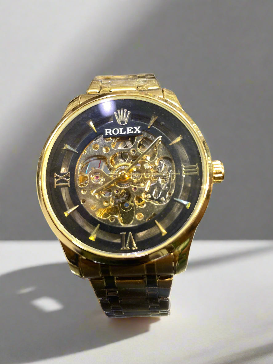 Gold Rolex watch with a clear face on a reflective surface